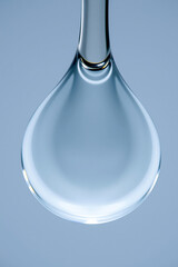 Poster - Macro photo of a transparent water drop on a light blue background. Illustrates purity, clarity, and the beauty of natures elements.