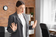 © Pixel-Shot - Young businesswoman trying to calm down while having panic attack in office