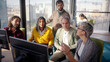© CarlosBarquero - Diverse professional team analyzing complex business data while collaborating near computer, city skyline visible through expansive office window during strategic meeting