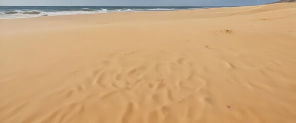 golden sand slopes to a tranquil azure sea, small waves lap gently , sun rays, sand, foam