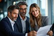 © Endri - Three professionally dressed businesspeople engaged in a meeting, discussing documents in a modern office with large windows, sharing a focused and collaborative atmosphere