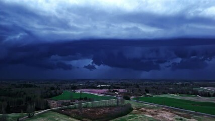 Wall Mural - drone footage of a landscape under dark, threatening storm clouds.