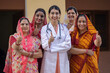© Pix4Ads - Concept of Indian rural women health care in India. Indian female doctor standing showing thumbs up with group of rural women rural health camp at village. Protection of cervical cancer