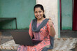 © Pix4Ads - Indian Rural Teenage Girl Student during online class on laptop. Portrait of Happy you while showing thumbs up at home village. indian school girl using laptop. Concept of skill india concept.