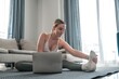 © shintartanya - home workout, mindfulness, wellness.Young woman practicing home workout dumbbells during online fitness session.pilates, strength training digital self-care routine.Healthy lifestyle