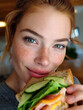 © Nick Freund - Junge Frau mit Sommersprossen isst ein Sandwich mit Avocado.