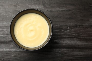 Wall Mural - tasty vanilla pudding in bowl on wooden table, top view. space for text