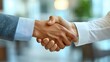 © YUTTAKARN - Two business people are closing a deal as they shake hands firmly in a bright office, symbolizing a successful partnership and cooperation on an agreement.