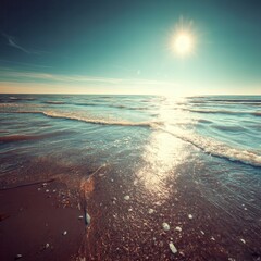 aerial view of ocean waves crashing on sandy beach under bright midday sun and clear blue sky.