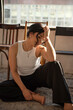 © Sergey - Woman sitting barefoot on the floor with a smile and closed eyes
