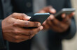 © miss irine - African hands hold mobile smartphones. Black man uses device to browse, check email, communicate, transfer data. Mobile tech for social media, business, digital marketing, online banking. Wireless