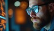 © miss irine - Bearded man with glasses intently looks at computer screen, possibly coding analyzing data. Focus on eyeglass reflection digital interface details. Modern office setting, tech-focused, with bokeh