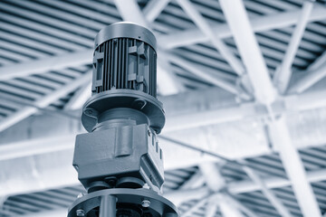 Fototapete - A machine with a motor on top of it. The motor is connected to a cable. The machine is in a large open space