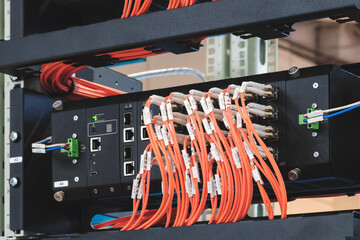 Poster - Red fiber optic wires inserted into electronic switching unit, industrial internet communication concept background.