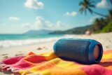 Compact portable Bluetooth speaker on a vibrant beach towel, showcasing portability and summer vibes , summer, device, sand