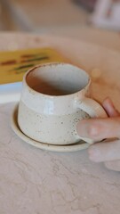 Fototapete - close-up shot of a woman's hands holding a cup of tea or coffee
