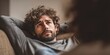 © BlackLion - Man with curly hair and beard listens intently during a conversation in a cozy indoor setting in the evening