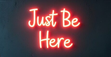 Poster - Bright red neon sign displays text Just Be Here against dark textured wall. Simple message, modern aesthetic.