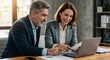 © Kalivmasa - Successful business partners reviewing documents together
