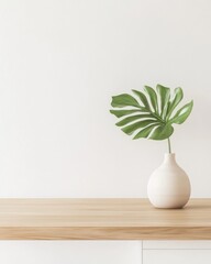 Poster - Monstera leaf in vase on wooden table against white wall minimalist interior design studio shot modern aesthetic