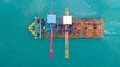 © Yellow Boat - Aerial view of a heavy lift vessel transporting massive port cranes across turquoise waters. Concept of industrial shipping, maritime logistics, port construction, and oversized cargo transportation.