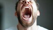 © Generative AI - Close-up portrait of a man with a beard, his mouth wide open in a yell, showing teeth and tongue.  High-detail image of human expression and emotion. : Generative AI