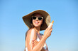 © verona_studio - Woman applying sunscreen creme on tanned shoulder. Skincare Concept.  Body Sun protection suncream. Gir applying moisturizing sunscreen lotion on back.