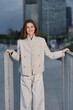 © SHOTPRIME STUDIO - confident woman in beige business suit standing outdoors with urban background smiling