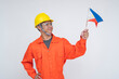 © Mdv Edwards - Young Southeast Asian male construction worker looking proudly at the Philippine flag, raising it high with respect and national pride. Isolated on a light background.