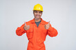 © Mdv Edwards - Young Southeast Asian male in orange coveralls and yellow hard hat giving double thumbs up, showing full approval and enthusiasm. Isolated on a light background.