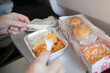 © Vladimir Razgulyaev - Enjoying InFlight Meal Experience Featuring Rice and Rolls Served on an Airplane Tray During the Flight. enjoying a delicious inflight meal with rice and fresh bread rolls, served on an airplane tray