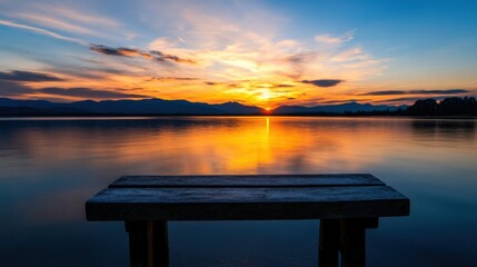 Poster - Serene sunset over a calm lake, reflecting vibrant orange and gold hues, with a weathered wooden bench in the foreground offering a peaceful view. : Generative AI