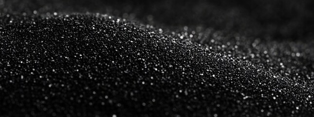 Aufkleber - Close-up view of a textured black surface, resembling dark sand or fine granules, with subtle light reflections creating a shimmering effect. : Generative AI