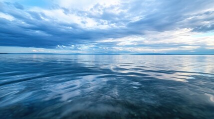 Poster - Serene lake landscape under a vast, dramatic sky, showcasing a tranquil water surface with subtle ripples reflecting the blue and gray clouds above. : Generative AI