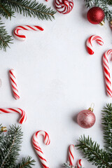 Poster - Festive Christmas border with candy canes, ornaments, and fir branches on a white background, perfect for holiday cards or invitations. : Generative AI