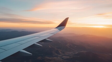 Poster - Airplane wing view over mountain range at sunset, showcasing vibrant orange and pink hues in the sky, with layers of mountains below. : Generative AI