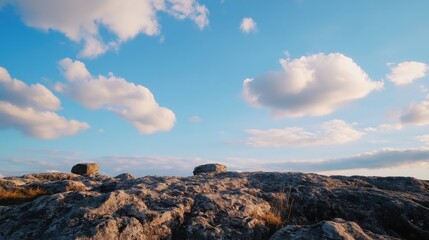 Poster - Serene landscape of gray rocks under a vibrant blue sky with fluffy white clouds, offering a peaceful and tranquil view. : Generative AI