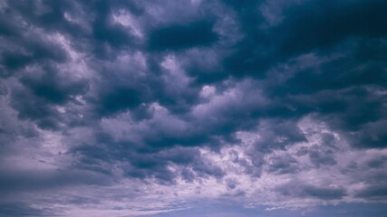 Wall Mural - Transition To Sunset Sky. Orange Sunset Sky Background. Natural Background Sky. Clouds Moving In Blue Sky From Day To Dusk Transition Timelapse. Abstract Bold Blue Color. Cloud Formation. Dusk Time