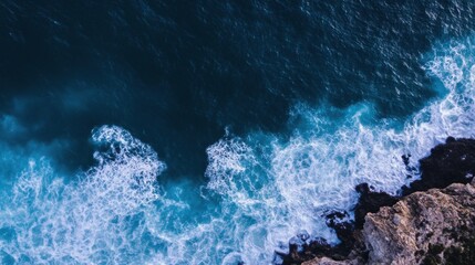 Fototapete - Aerial view of ocean waves crashing against a rocky coastline, showcasing a dramatic contrast between deep blue water and white foam. : Generative AI