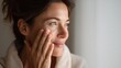 © Isolated studio - Woman Applying Organic Face Cream in Soft Natural Lighting