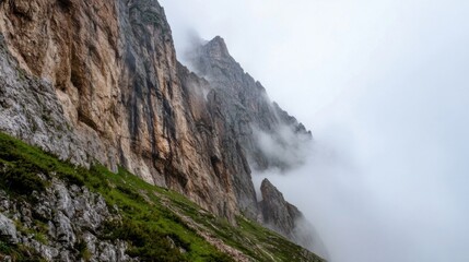 Leinwandbilder - Majestic mountain peak shrouded in mist, showcasing rugged rock formations and verdant slopes. A dramatic scene of nature's raw beauty. : Generative AI