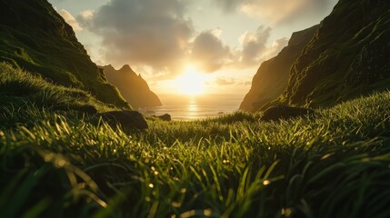 Poster - Beautiful landscape with a large body of water and mountains in the background. The sun is setting, casting a warm glow over the scene. The grass is lush and green