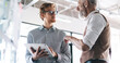 © BullRun - Two male professionals engaged in discussion over tablet and data charts, exchanging ideas and pointing to analytics board during collaborative session
