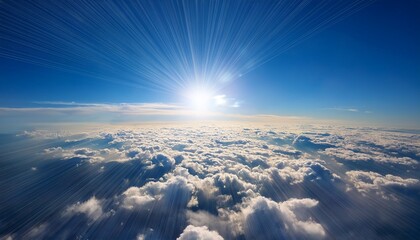 Wall Mural - view of the sky from above with clouds below the sun shining through the blue sky and the horizon in focus