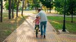 © Victoriia - Happy family, little girl in helmet together with her dad learns to ride bicycle outdoors in spring. Child cyclist with Father, nature. Family weekend. Father teaches kid daughter to ride bike in park