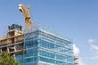 © Azulblue - Construction crane building modern office building under construction