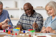 © Prostock-studio - Art therapy for seniors concept. Happy multiracial elderly men and women enjoying painting with brush, having conversation and smiling, attending drawing master-class together