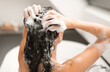 © Prostock-studio - Back View Of Female Applying Shampoo And Washing Head Taking Bath In Modern Bathroom Indoor. Woman Doing Haircare Routine Using Cosmetics. Beauty And Hair Care Concept. Selective Focus