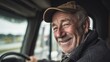 © Honey - Happy senior truck driver smiling in his vehicle cabin man old cap road face grey hair work smile