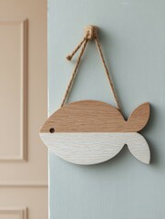 Poster - Wooden Fish Sign Hanging on a Pastel Wall Showcasing a Creative Decor Element for Coastal Themes in a Bright Indoor Space